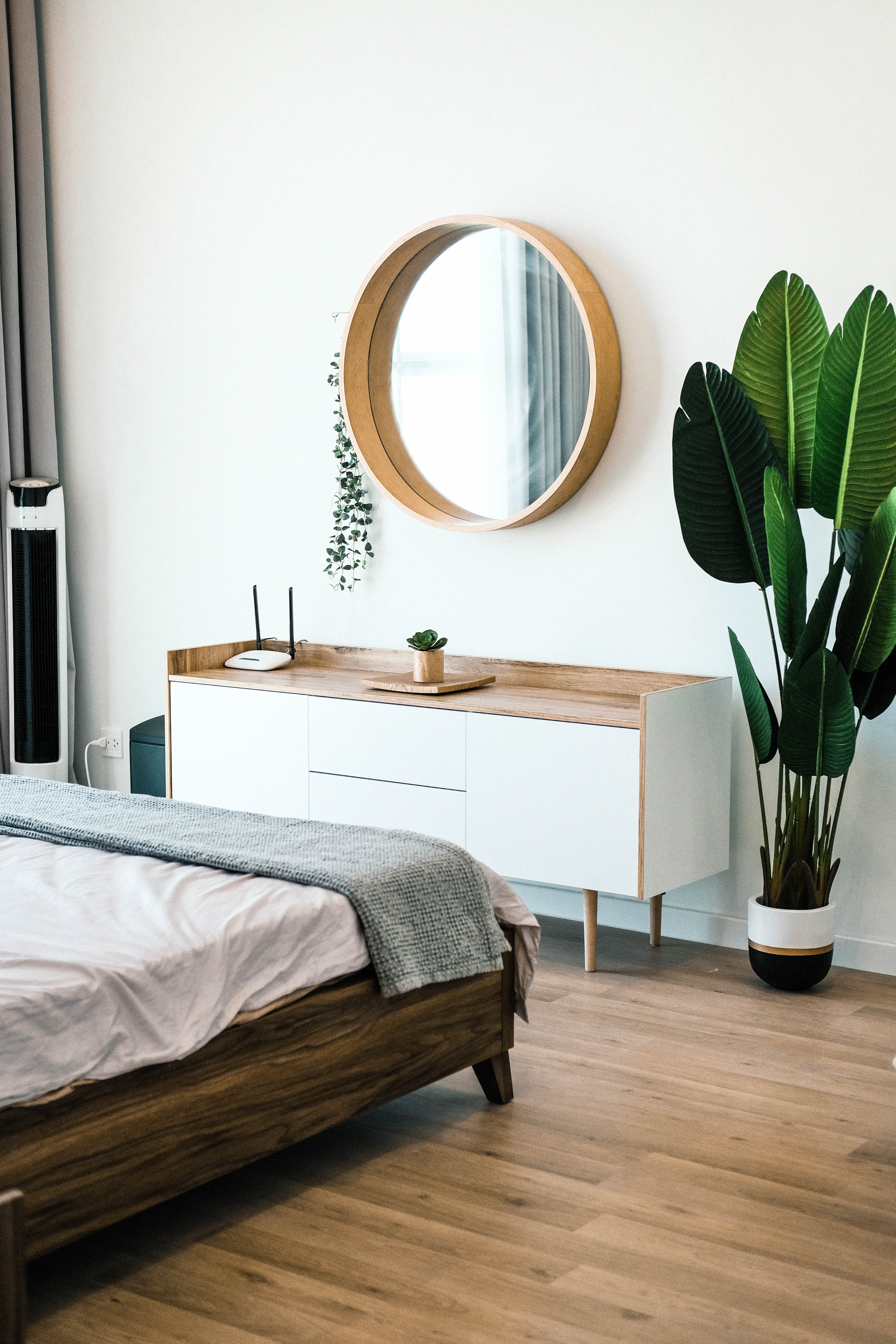 white bedroom with wood accents and green plants